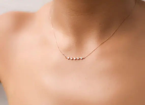 A woman wearing a minimal necklace with a row of diamonds.