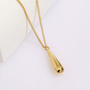 The Mermaid Tear Necklace, exuding elegance and sophistication, features a stunning gold plated tear drop pendant beautifully presented on a pristine white background.