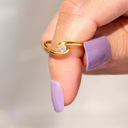 A woman's hand holding a Polaris Ring, glistening with the sparkle of a diamond, exuding glamour.