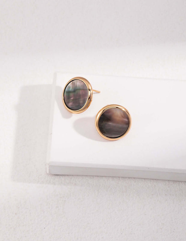 The Eclipse Earrings are a pair of gold-plated stud earrings with natural black mother of pearl.
