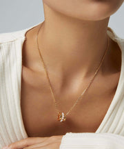 A woman wearing a white sweater and a Harper's Pearl Wheel Necklace plated.