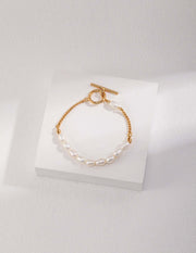A Chloe's Pearl Bracelet adorned with natural pearls and a gold chain.