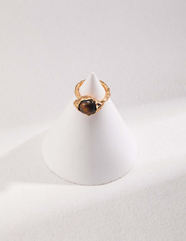 A white cone with a Tiger's Eye Ring on top and adjustable size.