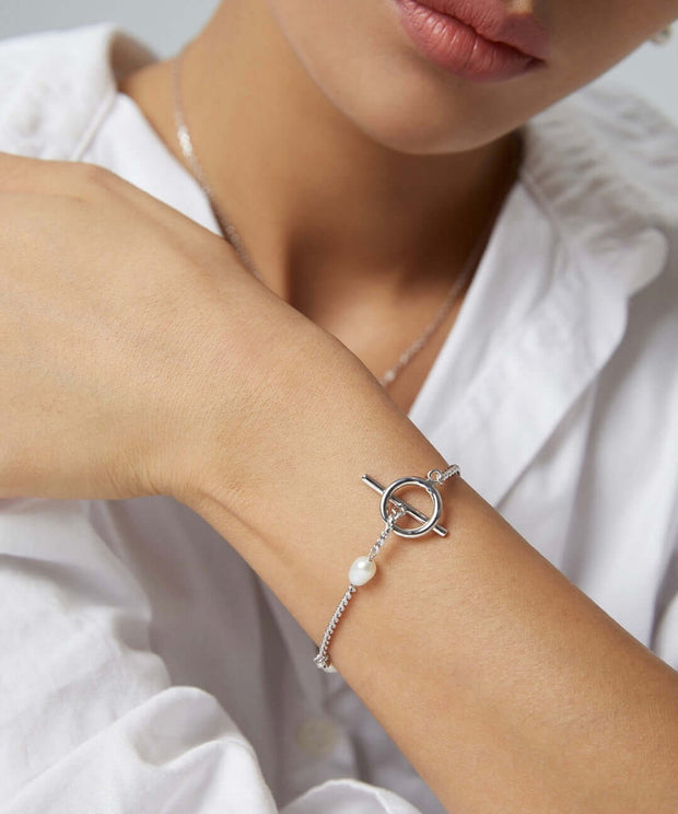 A woman wearing Chloe's Pearl Bracelet, featuring a natural pearl.