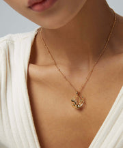 A woman wearing a Phoenix Grace Necklace with a bird pendant.