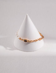 A white cone with a Tiger's Eye Pearl Bracelet on top.