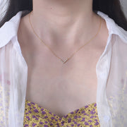 A woman showcasing timeless elegance with a statement piece - the Valentina Necklace. Wearing a yellow shirt, she elevates her style with the addition of this stunning Valentina Necklace.