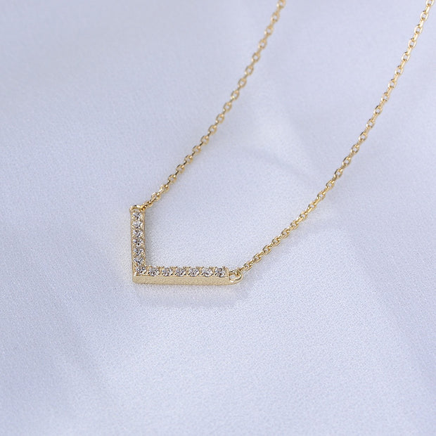 The Valentina Necklace is a timeless statement piece, featuring the Valentina Necklace, a gold-plated chevron design adorned with sparkling diamonds.
