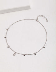 A silver choker with small star-kissed charms and a Starry Night Crescent Moon Necklace.
