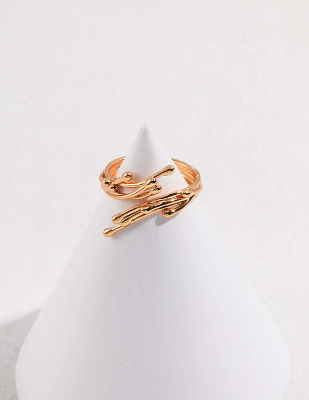 The Ethereal Twig Ring, a wardrobe staple, elegantly rests on top of a white pedestal.