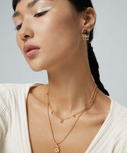 The model is wearing a white sweater and Starry Night Crescent Moon Necklace.