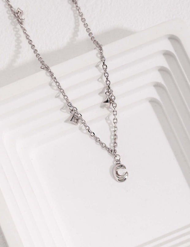 A Starry Night Crescent Moon necklace with a star and a moon on it, giving it a star-kissed look.