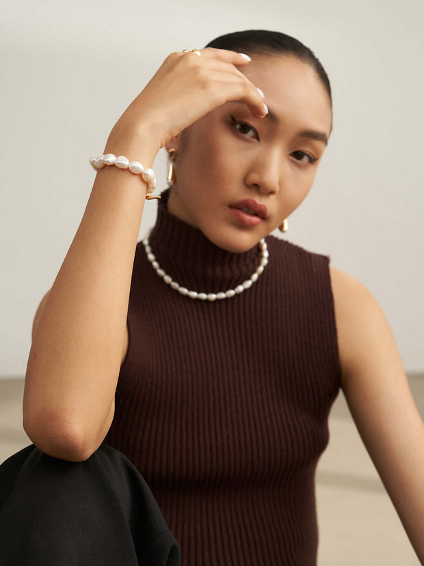 A woman wearing a brown sweater and Baroque Pearl Bracelet.