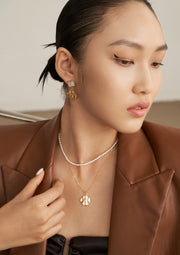 A fashionable woman adorned in a brown jacket and the elegant Natural Pearl Double Layered Necklace.