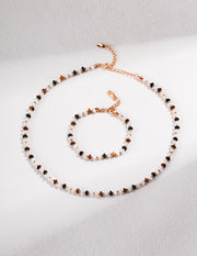 A Tigerite Charm Choker necklace and bracelet set with black and white beads.