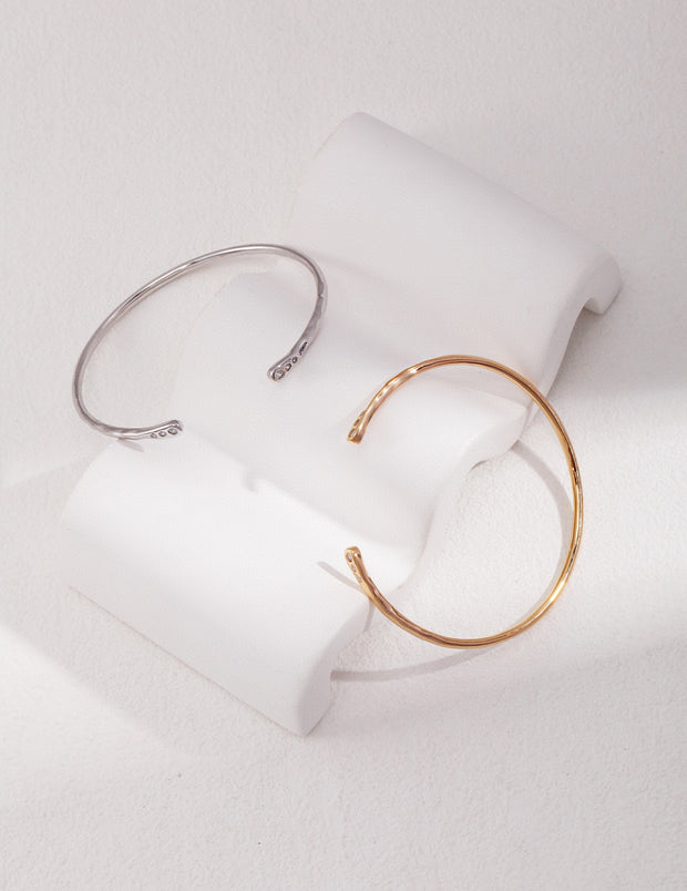 A timeless pair of Minimalist Chic Bangles on a white surface, exuding a minimalist chic look.