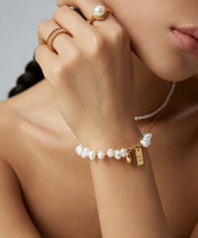 A woman wearing a Golden Heart Pearl Bracelet and a gold ring.