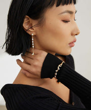 A woman wearing a black sweater and Lunar Mist Bangle.