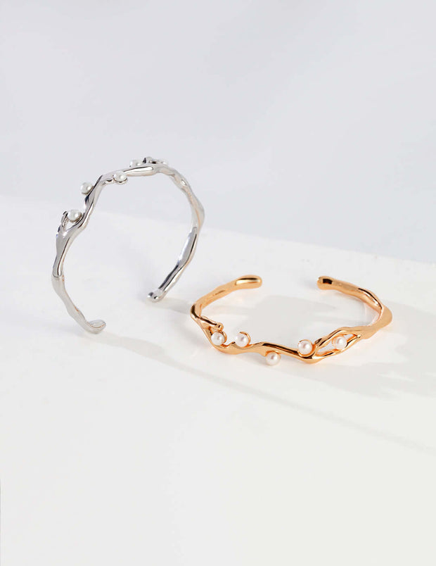 Two Lunar Mist Bangle cuff bracelets on a white surface.