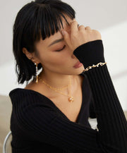 A woman wearing a black sweater and Lunar Mist Bangle.