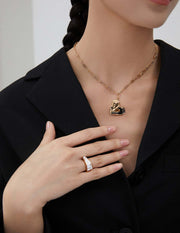 A woman wearing a black jacket with an eye-catching necklace and the Modernist Contrast Ring.