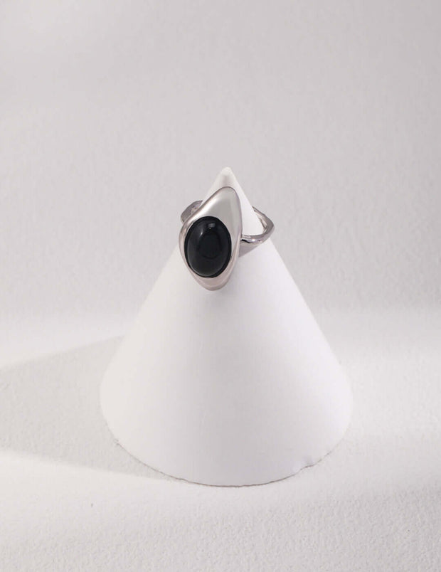 Artisan Carved Agate Ring with a black onyx stone on a white pedestal, giving it a unique and elegant style.